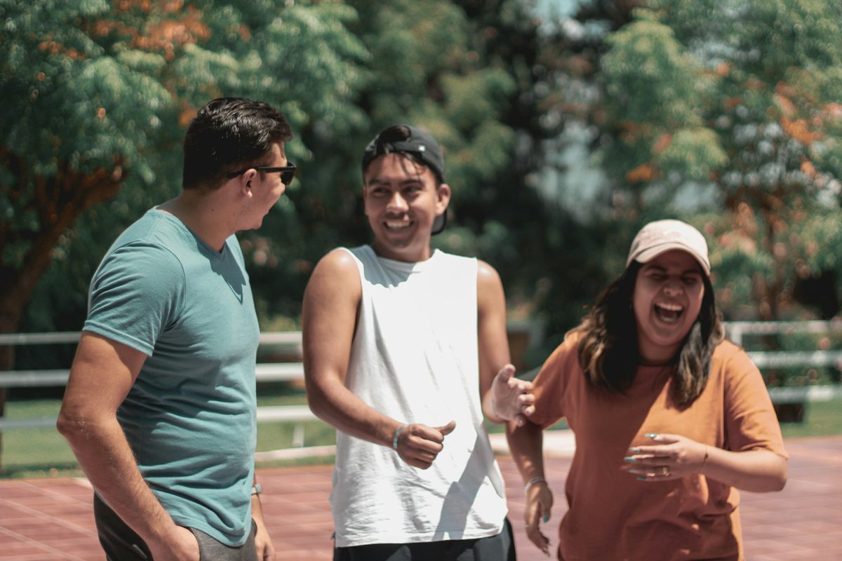 Three friends laughing together outdoors